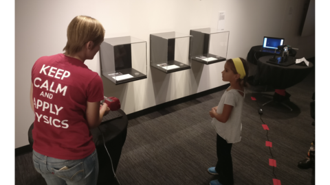 Applied Physics graduate student Emily presents Schlieren imaging to a young girl